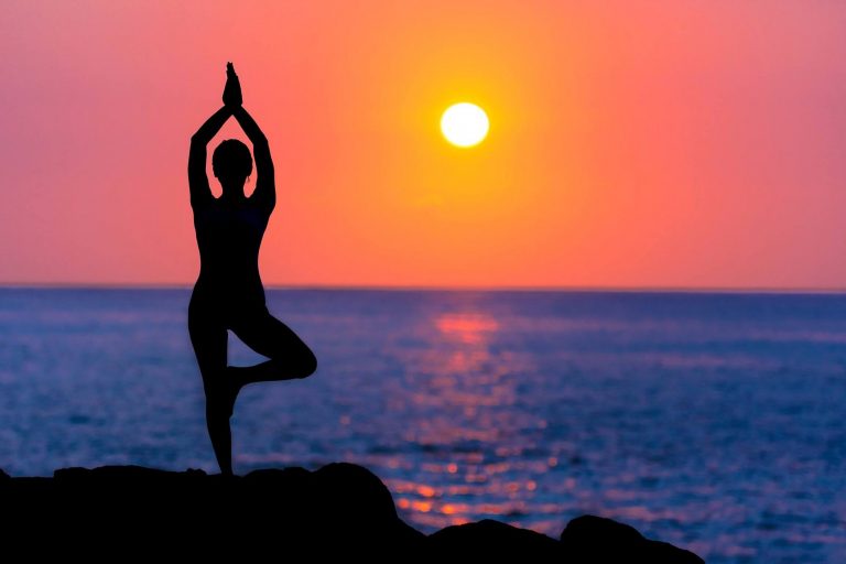 Home Yoga Ashram ochtendtraining met deelnemers die Hatha Yoga oefenen bij zonsopgang in een natuurlijke omgeving